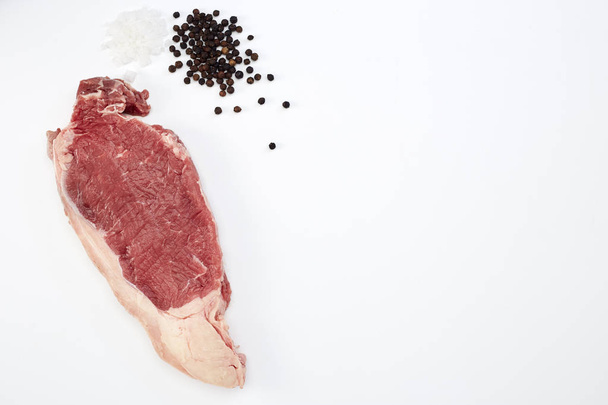 Fresh raw beef steak with spices  on white - Zdjęcie, obraz