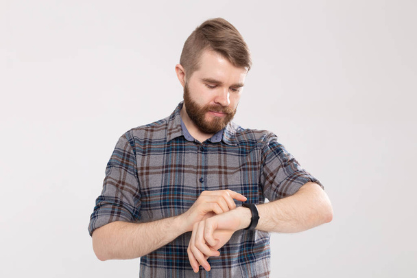 Retrato de close-up de um homem de fitness usando smartwatch no fundo branco
 - Foto, Imagem