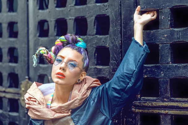 Pouliční módní portrét modelky s pestrou pletenou srstí a městským oblečem, avantgardní styl hipsterské ženy s pronikavým a chladným brýlemi, futuristický styl dospívání - Fotografie, Obrázek