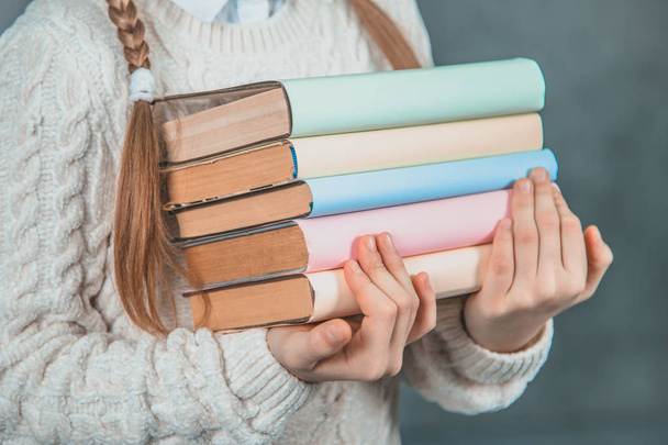 Ready to study hard Strong smart girl is holding books and is isolated on grey background. - Foto, Imagen