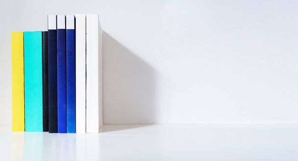 Books on white shelf and white wall, with copy space - Fotoğraf, Görsel