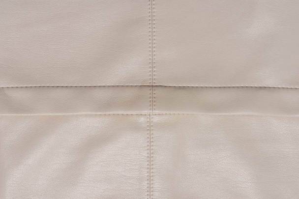 Surface beige cuir divisée sur quatre pièces paires. Fond abstrait avec espace de copie. Une couture de bonne qualité
.  - Photo, image