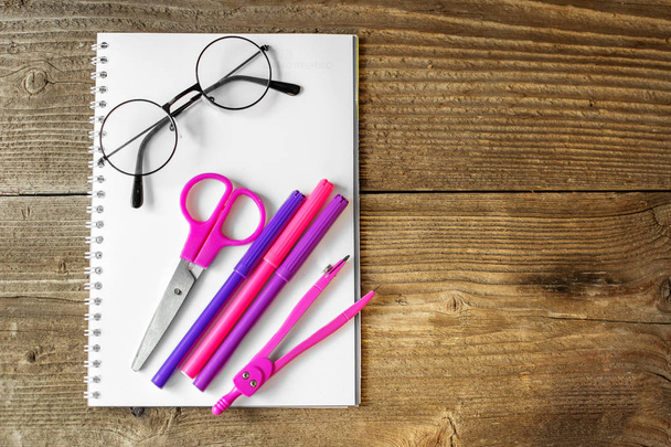 Розовые ножницы, блокнот и маркеры. Понятие школы, творчества, детства
. - Фото, изображение