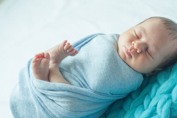 自宅のベッドの上に青い毛布のかわいい赤ちゃん - 写真・画像
