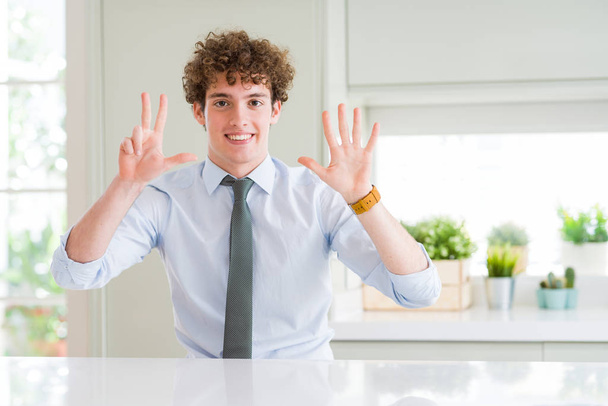 自信を持って幸せそうに微笑みながら、指を指差して指を上げるネクタイを着た若いビジネスマン. - 写真・画像