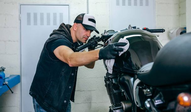 Mechaniker putzt ein Motorrad - Foto, Bild