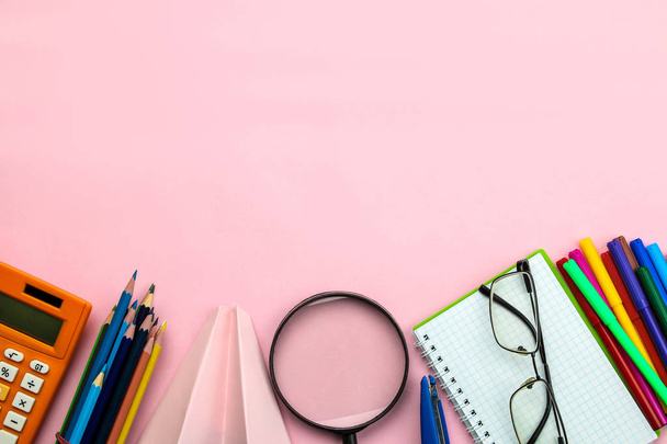 明るいピンクの背景に様々な学校用品のノート、鉛筆やメガネ。学校に戻るオフィス ツール。教育。トップビュー. - 写真・画像