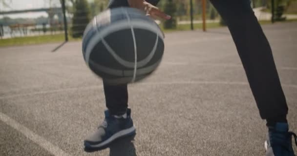Closeup portrait of young sporty african american male basketball player throwing a ball into a hoop outdoors on the court - Záběry, video