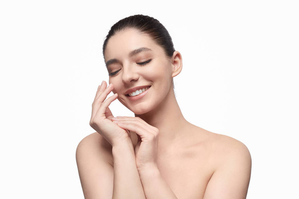 Smiling model smearing cream on hands - Photo, Image