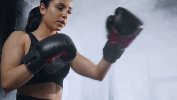 krásně zaměřený sportovní sportovce s boxovací brašnou v tělocvičně - Záběry, video