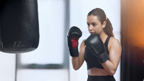 szép fókuszált sportiomán gyakorlása a boxzsák a tornateremben - Felvétel, videó