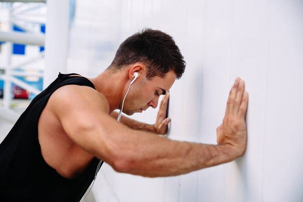 Side view of brawny guy doing sports exercises, outdoors - Valokuva, kuva