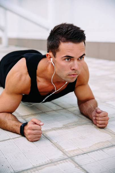 Sportsman doing push ups on elbows, outdoors - Zdjęcie, obraz