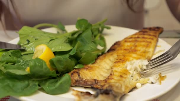 Frau isst im Café frittierten Fisch mit grünen Blättern, Hände in Großaufnahme. - Filmmaterial, Video
