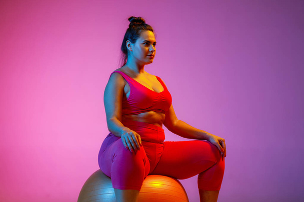 Young caucasian plus size female models training on gradient background - 写真・画像