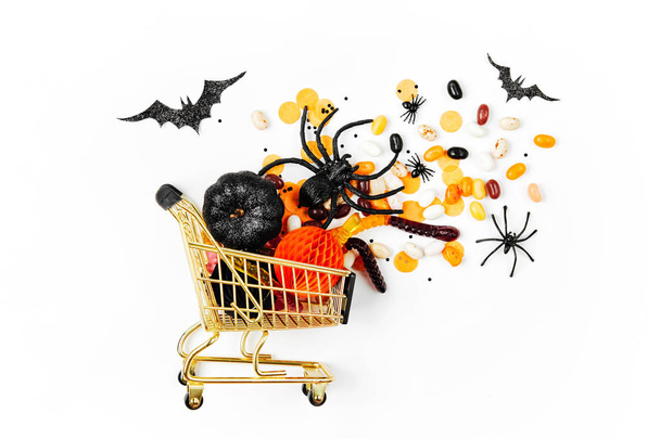 Halloween treats in shopping cart on white background, Halloween concept  - Foto, afbeelding