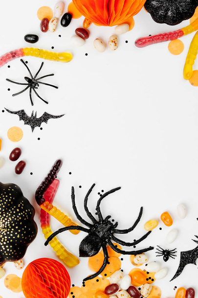Halloween holiday decorations, colorful candy, bats, spiders on white background - Fotó, kép