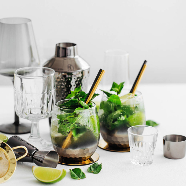 Cocktails with lime, mint and ice and bar accessories - Fotografie, Obrázek