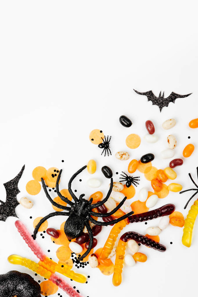 Halloween holiday decorations, colorful candy, bats, spiders on white background - Valokuva, kuva