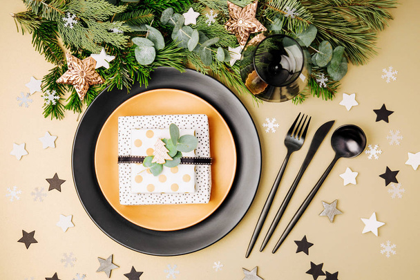 Black plates with gift and Christmas decorations with fir-tree branches - Valokuva, kuva