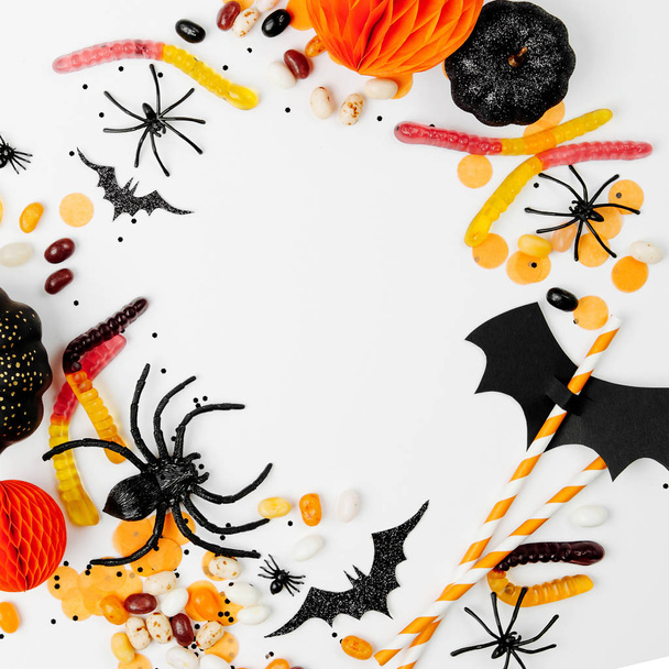 Halloween holiday decorations, colorful candy, bats, spiders on white background - Photo, Image