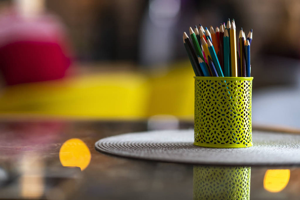 A lot of colorful pencils in pencil holder on the table in design studio agency. Art object. - Photo, Image