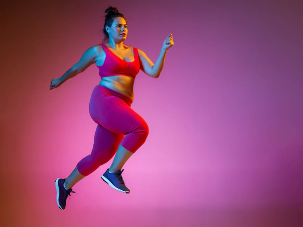 Young caucasian plus size female models training on gradient background - 写真・画像