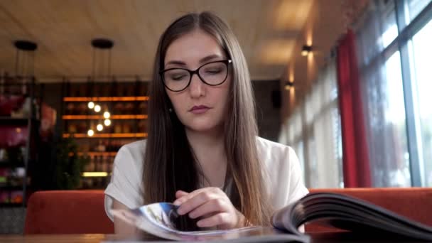 Uroda młoda kobieta czytanie menu. - Materiał filmowy, wideo