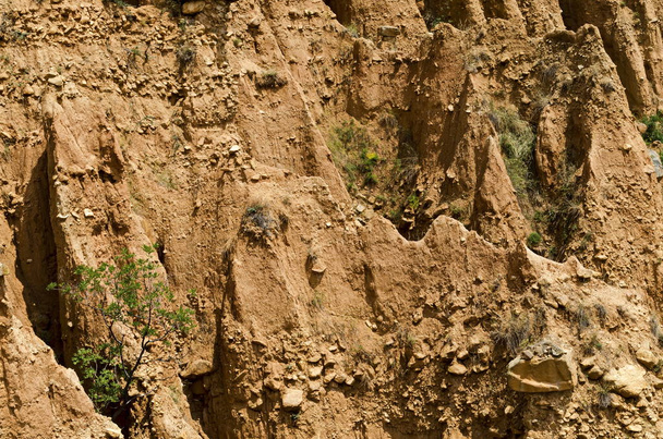 Al cierre de las famosas pirámides de Stob con formas inusuales formaciones rocosas rojas y amarillas, arbustos verdes y árboles alrededor, parte oeste de la montaña Rila, región de Kyustendil, Bulgaria, Europa
   - Foto, imagen