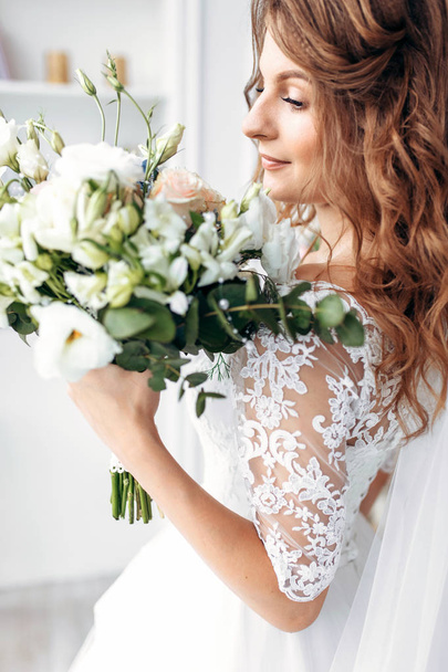 Beautiful bride in a wedding dress with lace, posing in the Studio - Fotó, kép