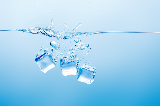 transparent pure water with splash and ice on blue background - Photo, Image