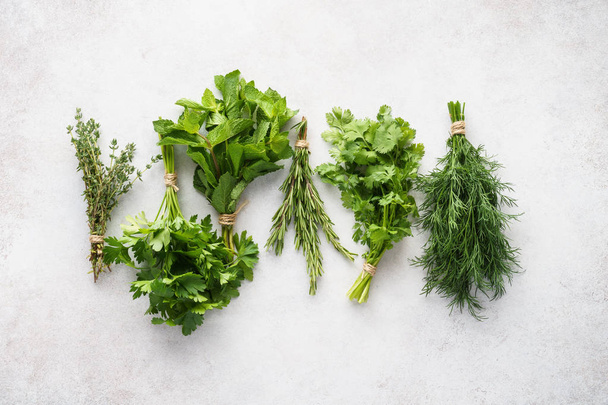 Different fresh herbs on gray background. Healthy ingredients. - Фото, зображення