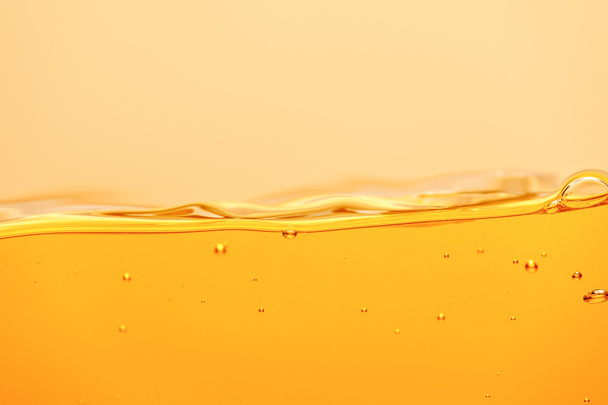 liquide brillant jaune ondulé avec éclaboussures et bulles isolées sur jaune
 - Photo, image