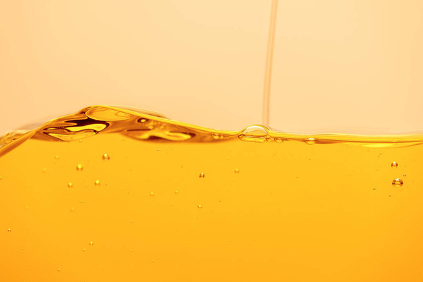 pouring yellow bright liquid with bubbles isolated on yellow - 写真・画像