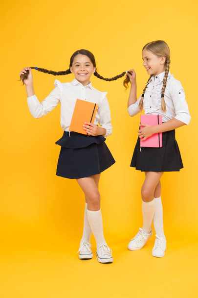 happy girls study with workbook. reading and writing. small girls kids with book. literature lesson. childrens literature. back to school. Classmates at book store or library. interesting book - Φωτογραφία, εικόνα