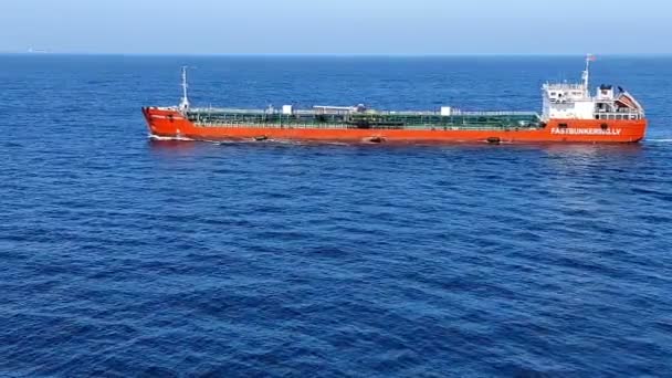 lange rode olietanker met gekleurde pijpen vaart op eindeloze zee - Video