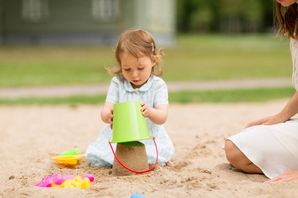 little baby girl plays with toys in sandbox - Valokuva, kuva