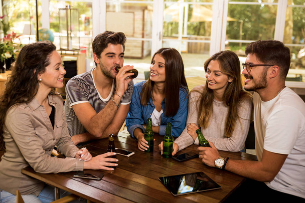 A group of friends at the bar drinking a beer  - Photo, image