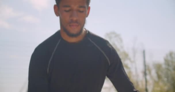 Closeup portrait of sporty african american male hands training with a basketball ball warming up on the court in the urban city outdoors - Footage, Video