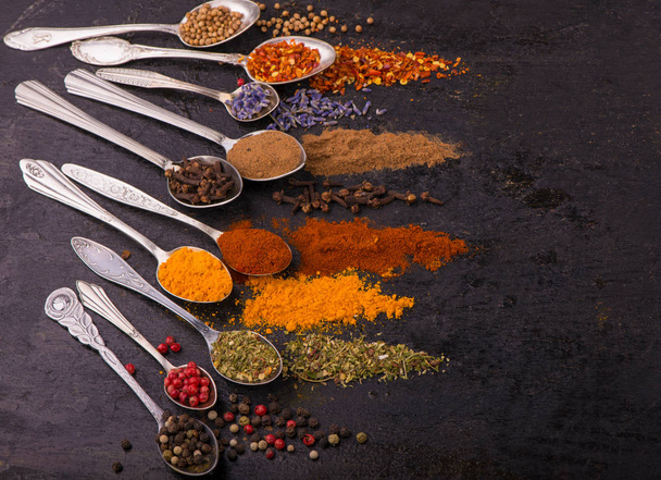 Spices and condiments for cooking on a black background - Foto, Imagen
