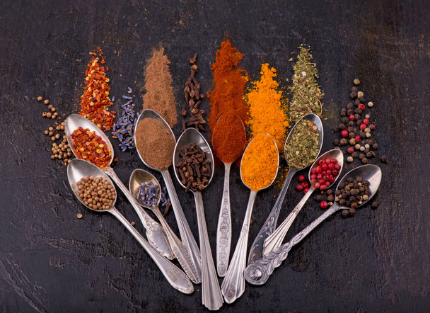 Spices and condiments for cooking on a black background - Fotó, kép