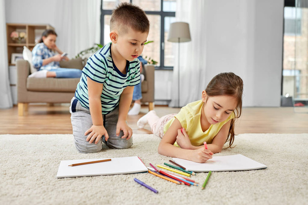 brother and sister drawing with crayons at home - Foto, imagen