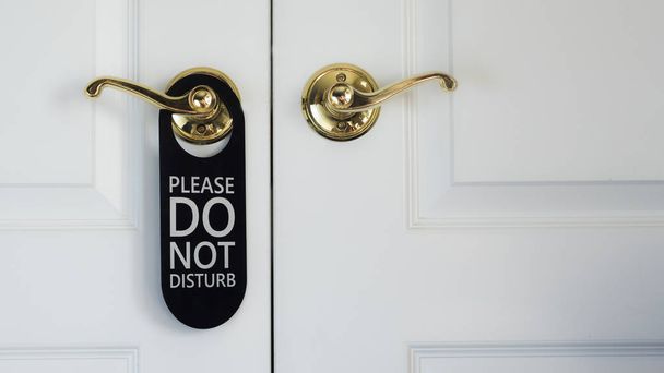 The plate on the door Do not disturb. Hanging on the white door in the hotel - Foto, Imagen