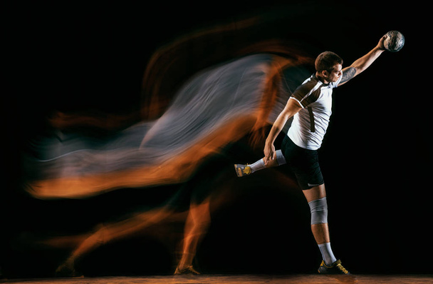 Молодой гандболист на фоне темных студий в смешанном свете
 - Фото, изображение