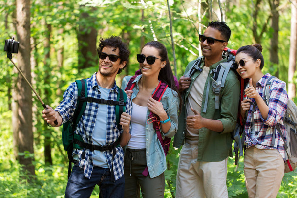 friends with backpacks hiking and taking selfie - Photo, image