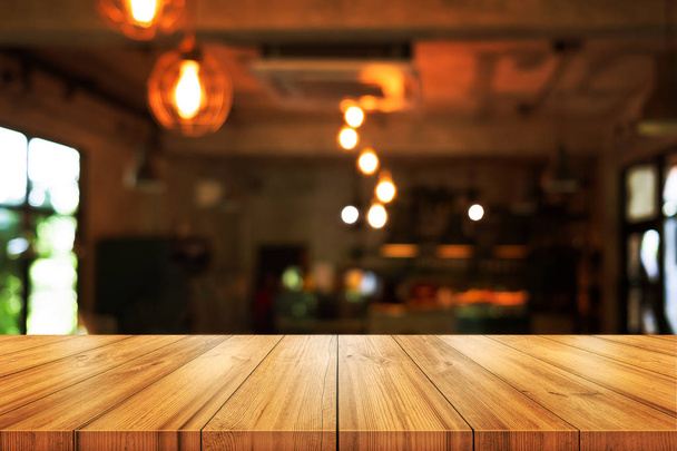 Empty wooden table top with blurred coffee shop or restaurant interior background. can be used product display.  - Foto, Bild