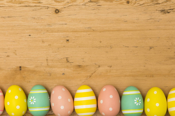 Painted Easter eggs on a wooden background - Φωτογραφία, εικόνα
