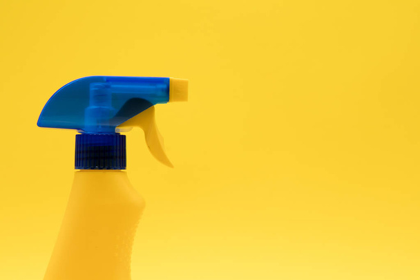 Cleaning spray bottle products on a bright yellow background - Фото, изображение
