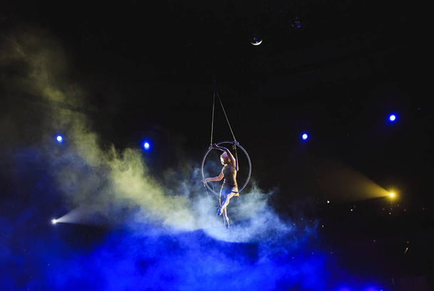 Aerial acrobat in the ring. A young girl performs the acrobatic elements in the air ring. - Foto, Imagem