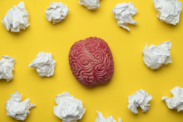 Brainstorming ideas. Brain with crumpled paper on a yellow backg - Zdjęcie, obraz